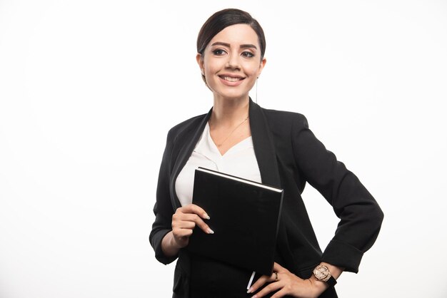 Smiling woman posing with notebook on white background. High quality photo