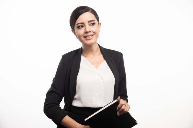 Smiling woman posing with notebook on white background. High quality photo