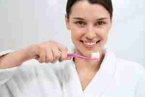 Free photo smiling woman preparing for cleaning teeth in bathroom