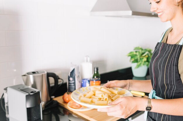 Smiling woman preparing pasta