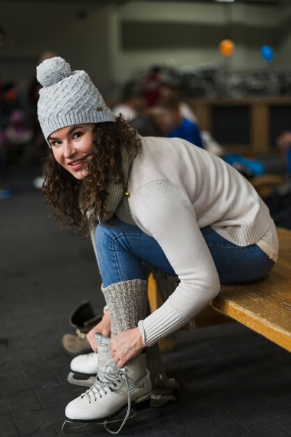 Smiling woman putting on ice skates