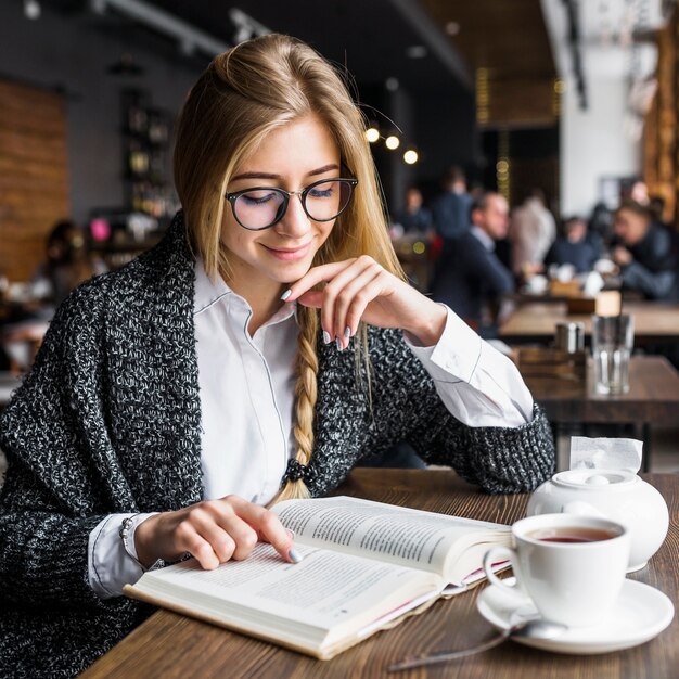 Улыбка женщины чтение книги в кафе