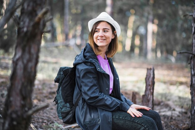 Smiling woman resting on log