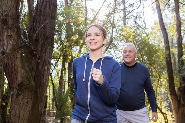 Smiling woman running with her grandfather