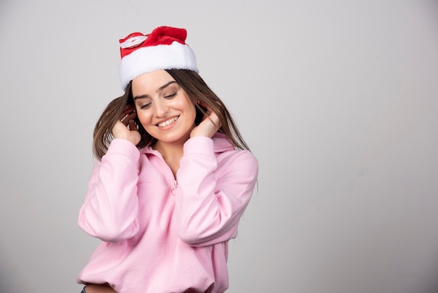 머리를 수정 하는 산타 클로스 빨간 모자에 웃는 여자.