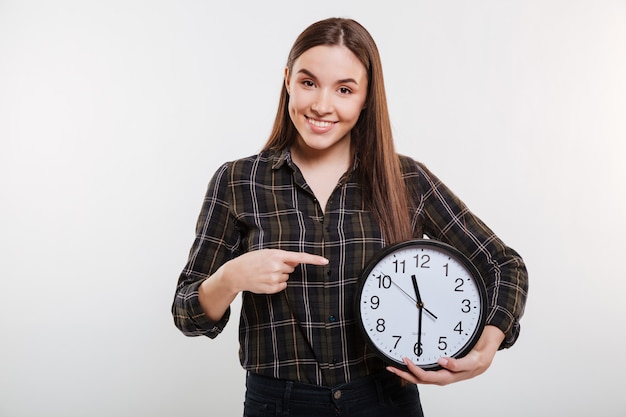 Donna sorridente in camicia che tiene l'orologio