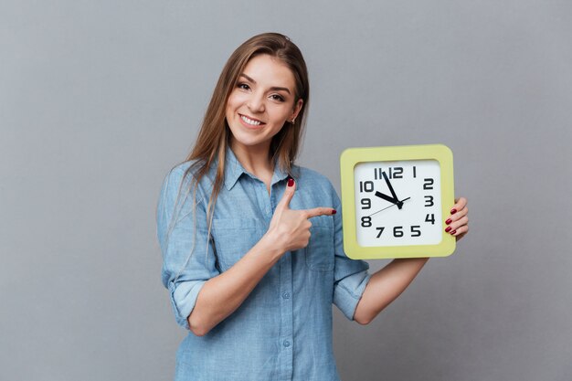 Smiling Woman in shirt holding clock