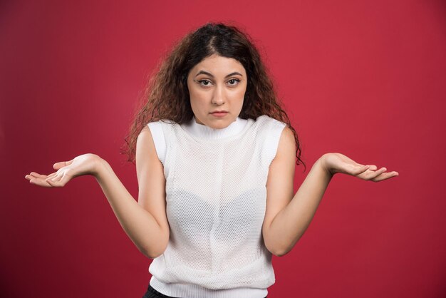 Smiling woman showing her hands on red