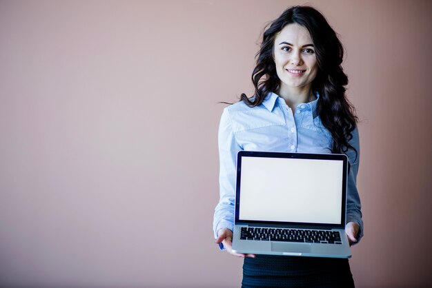 Smiling woman showing laptop