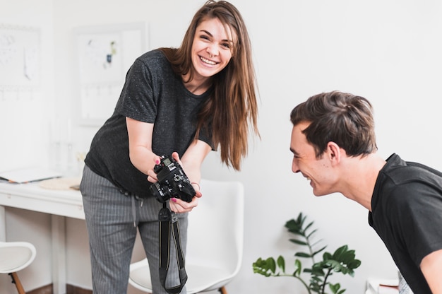 그녀의 남자 친구에게 카메라에 사진 촬영을 보여주는 웃는 여자