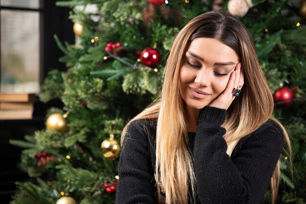 A smiling woman sitting on cozy sofa thoughtfully. High quality photo