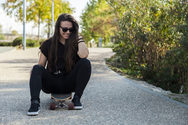 Smiling woman sitting on longboard