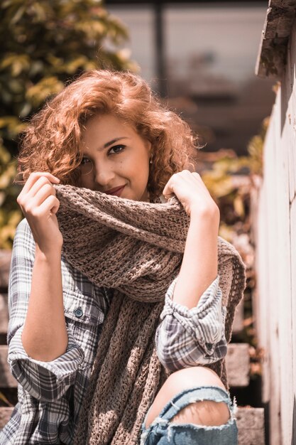 Smiling woman on steps holding scarf