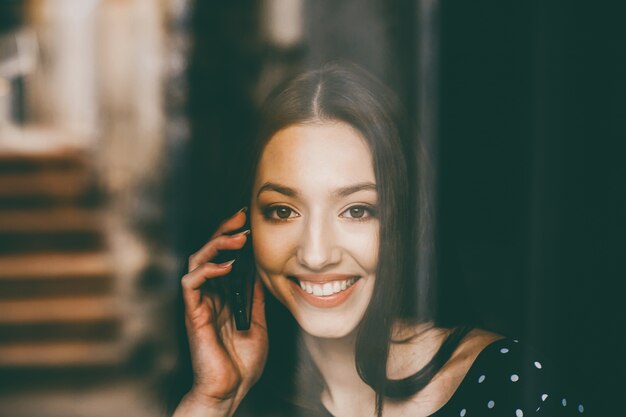 Smiling woman talking on the phone with her friend