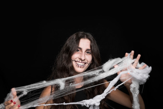 Free photo smiling woman tangling in fake cobweb