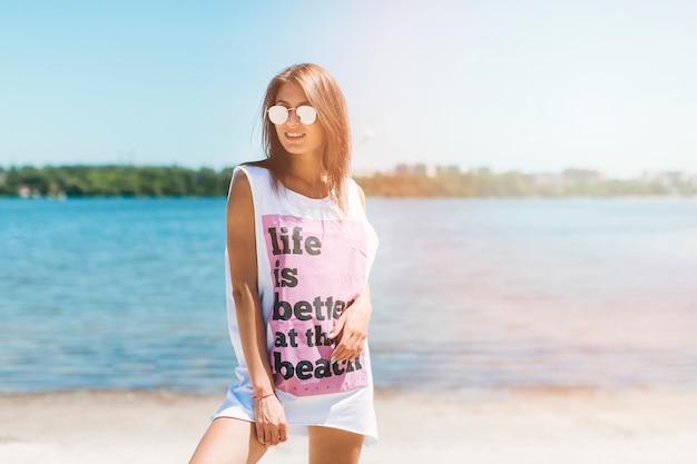 Smiling woman in tank top on beach