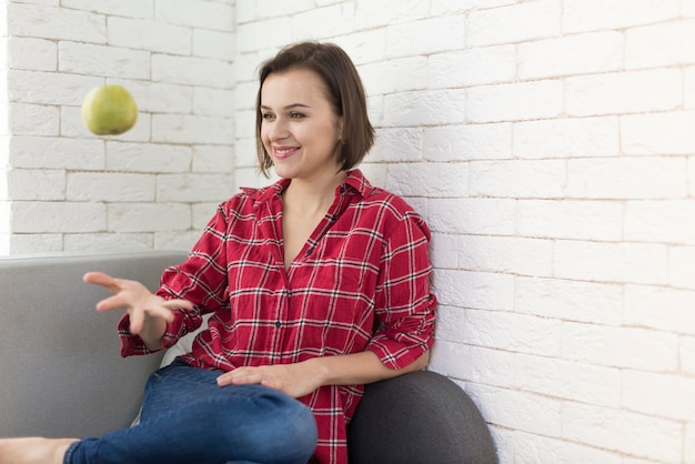 Free photo smiling woman throwing apple