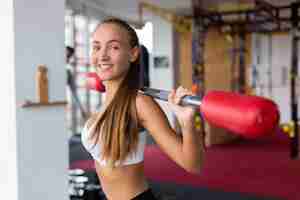 Free photo smiling woman training with weight bar