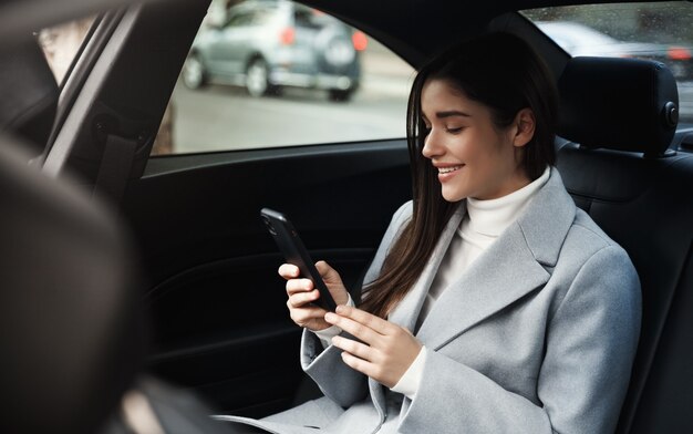 Smiling woman traveling by a car