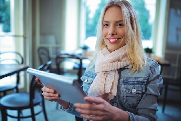 カフェでデジタルタブレットを使用して女性を笑顔