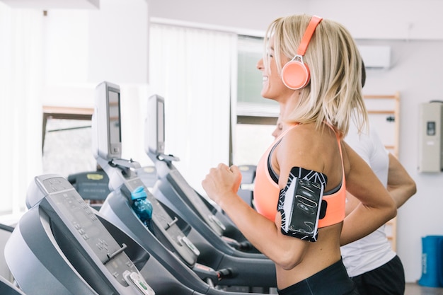 Smiling woman using treadmill