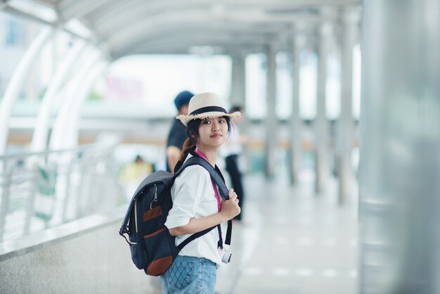 산책로 및 백그라운드에서 건물 도시 광경을 감상하는 젊은 아가씨 야외 산책, 웃는 여자.