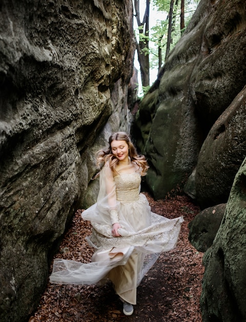 Free photo smiling woman walking in between rocks