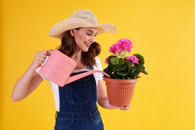 植木鉢で花に水をまく女性の笑顔