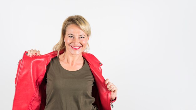 Smiling woman wearing red jacket looking at camera against white background