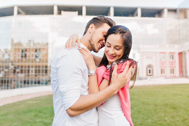 Smiling woman wears trendy accessories embracing boyfriend