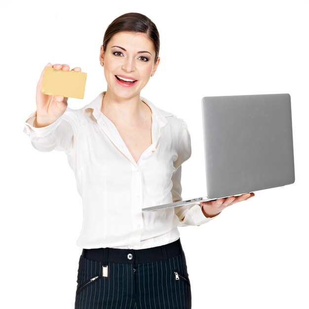 Smiling woman in a white shirt  with  laptop and credit card  isolated on white.