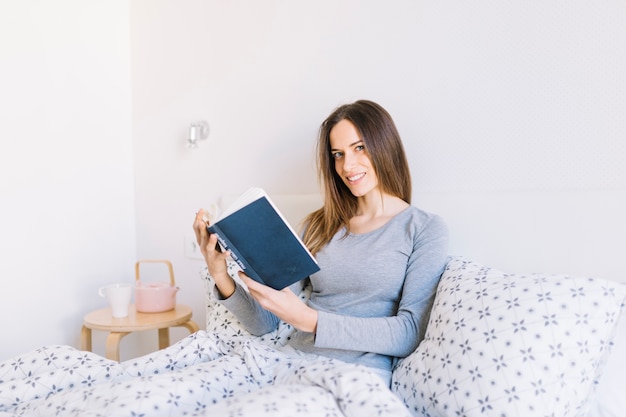 Free photo smiling woman with book looking at camera