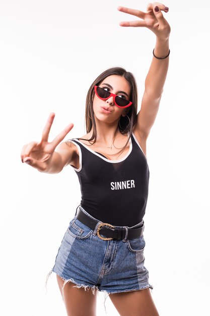 Smiling woman with braces and red sunglasses shows victory sing on both hands