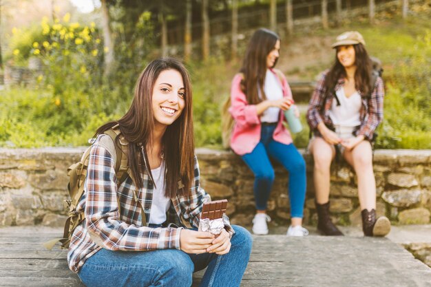 Smiling woman with chocolate near friends