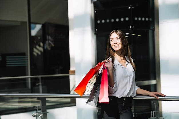 Foto gratuita donna sorridente con sacchetti di carta colorati