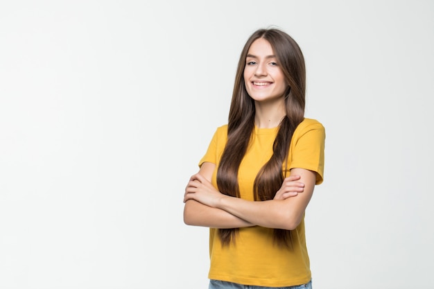 Donna sorridente con le braccia attraversate isolata sulla parete bianca.