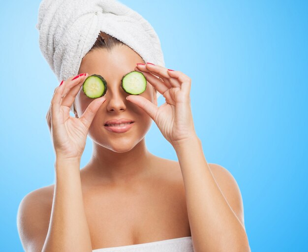 Smiling woman with cucumbers on eyes