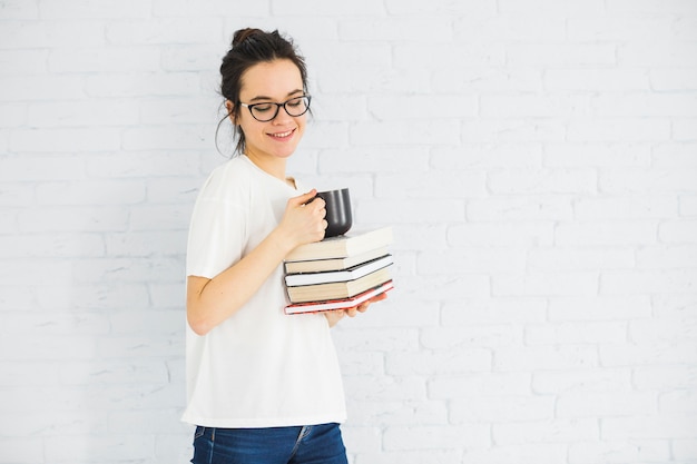 Smiling woman with cup and books