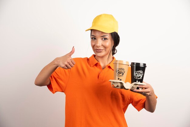 Smiling woman with cups showing thumb up