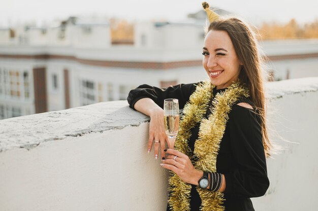 Smiling woman with glass of champagne on a rooftop