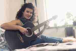 Free photo smiling woman with guitar