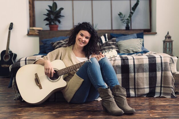 Foto gratuita donna sorridente con la chitarra