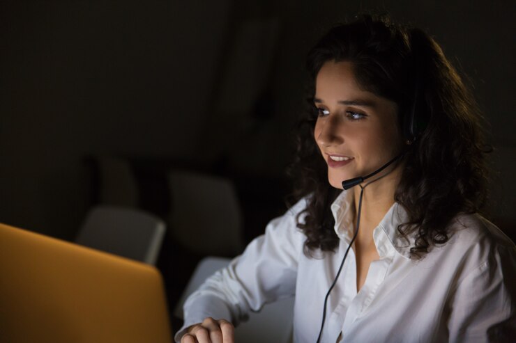 Free Photo smiling woman with headset in dark office