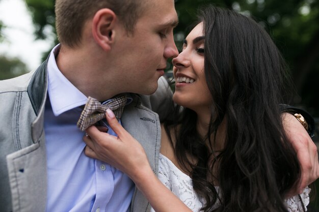 Smiling woman with her left hand on her husband's bow tie