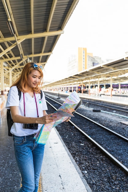 Foto gratuita donna sorridente con mappa sulla piattaforma