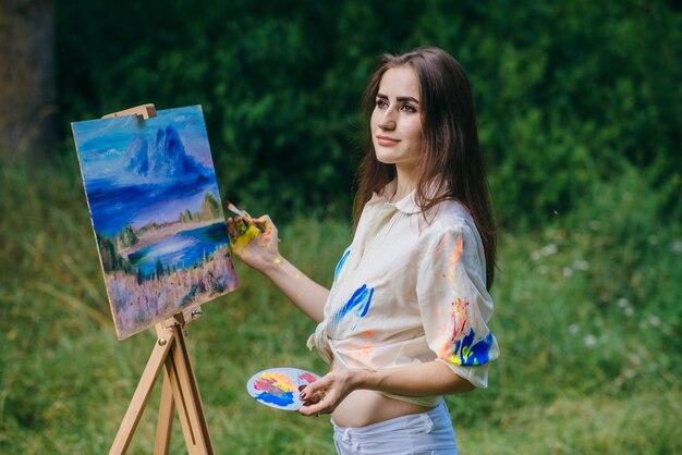 Smiling woman with a paintbrush in a hand