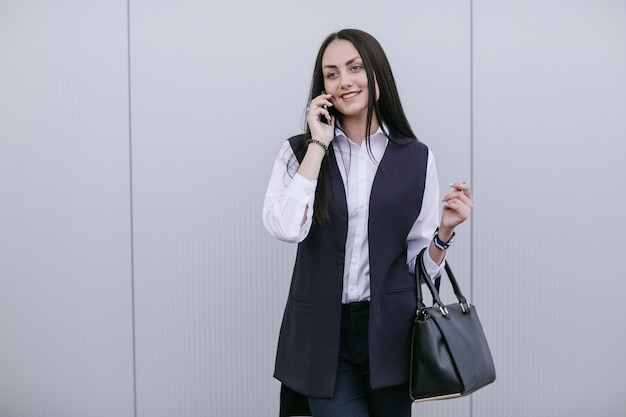 Donna sorridente con un telefono in un orecchio