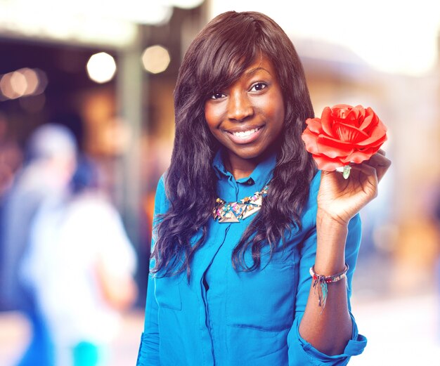 Donna sorridente con un fiore rosso