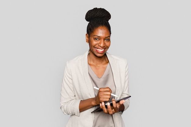 Free photo smiling woman writing notes on tablet digital device