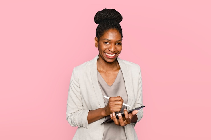 Free Photo smiling woman writing notes on tablet digital device